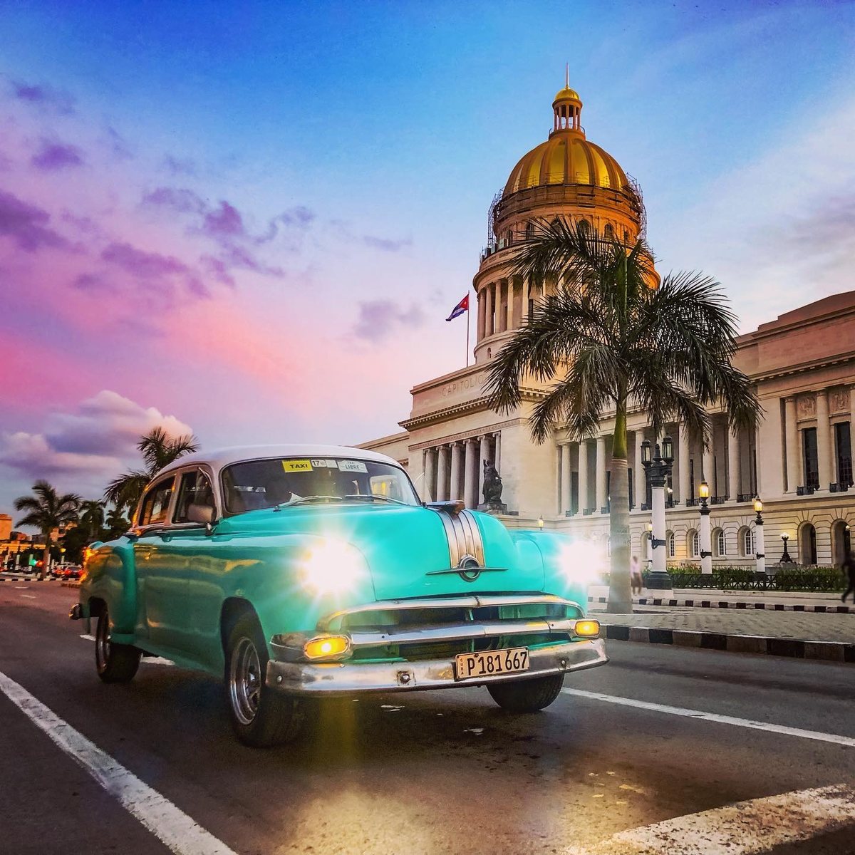 Voiture ancienne turquoise devant le Capitolio de La Havane au coucher du soleil